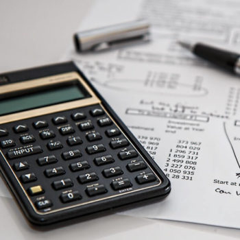 calculator alongside pen and receipt with writing on