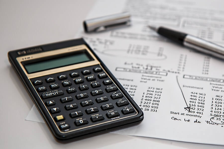 calculator alongside pen and receipt with writing on