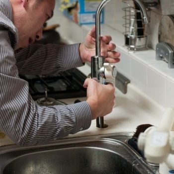 man fixing tap and giving plumbing help