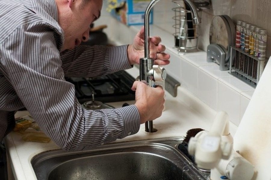 man fixing tap and giving plumbing help